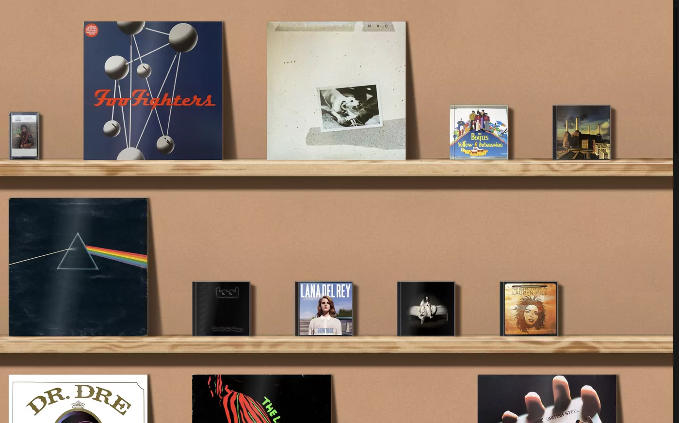 Records and CDs in Drisiúr, standing on wooden shelves: LP sleeves leaning against the wall, with CDs in jewel cases and a cassette beside them.